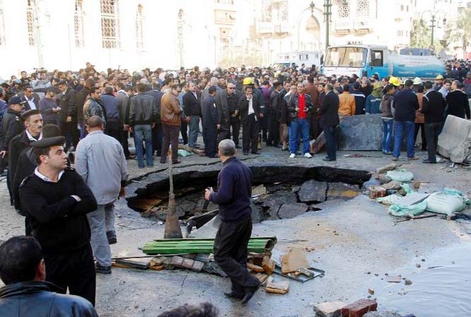 Egyptian emergency personnel and civilians gather at the site of a car bomb explosion outside the Cairo police headquarters on Friday.