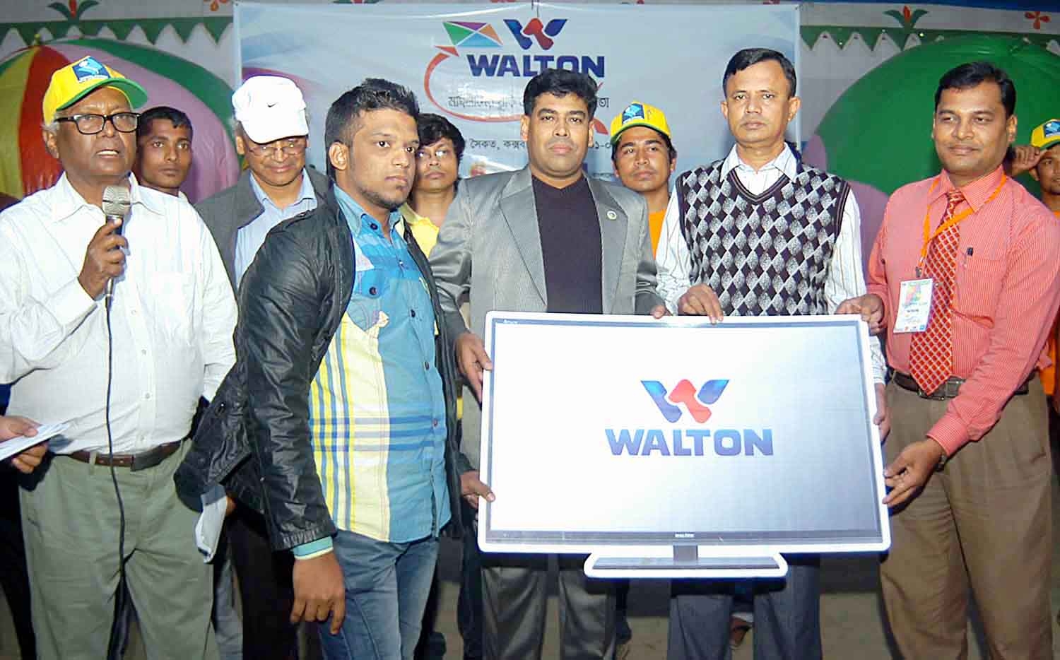 Khairul of Kashaituli of Dhaka receiving the Walton television at the Cox's Bazar Seashore on Saturday. Khairul became second in the Walton National Kite Festival, which was held at the Cox's Bazar Seashore. DC of Cox's Bazar Ruhul Amin, Additional Dir