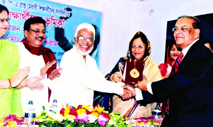 Dr M Mosharraf Hossain, Chairman and Managing Director. Rapport Bangladesh Limited is seen receiving Nelson Mendela Gold Medal from former Chief Justice Mohammad Fazlul Karim recently in a function hled in Dhaka organized by Bangladesh Medha Bikash Societ
