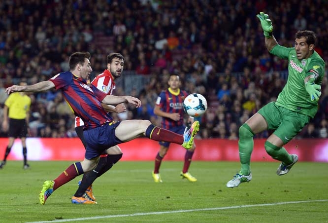 FC Barcelona's Lionel Messi from Argentina (left) duels for the ball against Athletic Bilbao's goalkeeper Gorka Iraizoz during a Spanish La Liga soccer match at the Camp Nou stadium in Barcelona, Spain on Sunday.