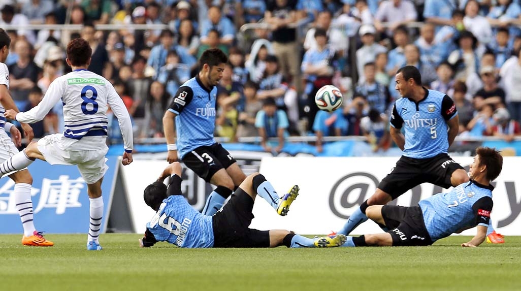 Ventforet Kofu's Ryohei Arai (3) attempts to score against Kawasaki Frontale's defenders during a J-League soccer match in Kawasaki near Tokyo Saturday.