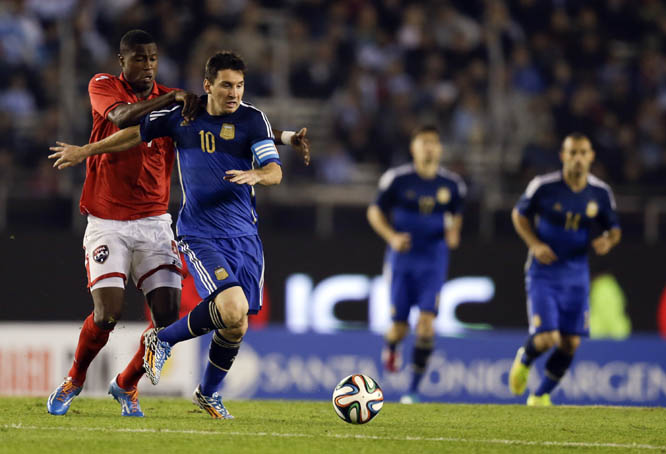 Argentina's Lionel Messi (second left) fights for the ball with Trinidad and Tobago's Sheldon Bateau (left) during their international friendly soccer match in Buenos Aires, Argentina on Wednesday.