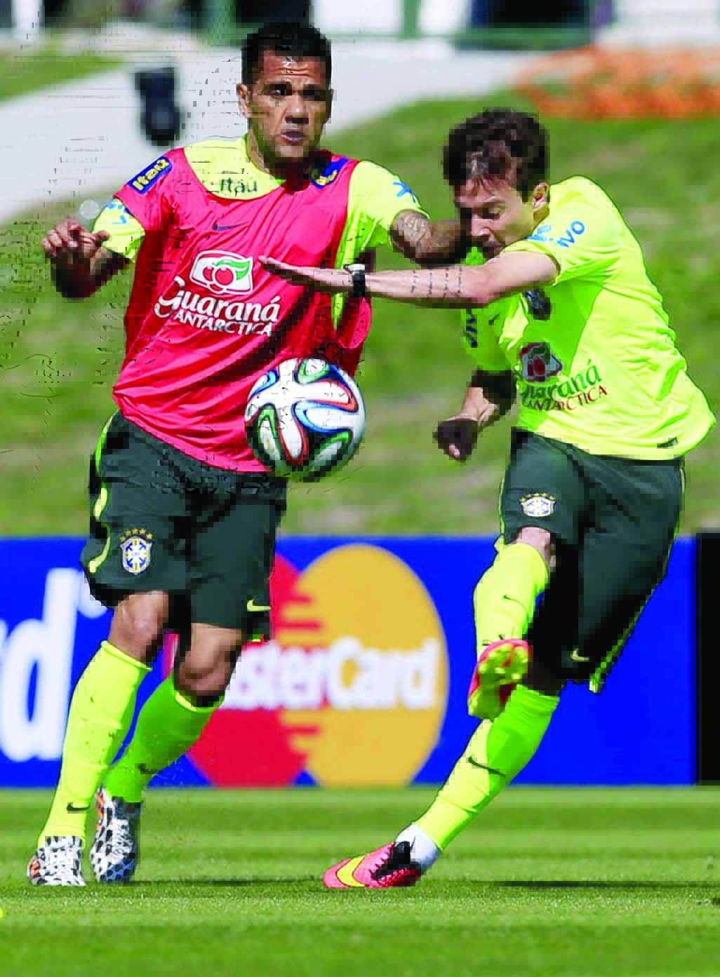 Brazil's Daniel Alves (left) and Bernard fight for the ball during a practice session at the Granja Comary training center in Teresopolis, Brazil on Thursday. Brazil will face Croatia at the opening match of the World Cup soccer tournament on June 12.