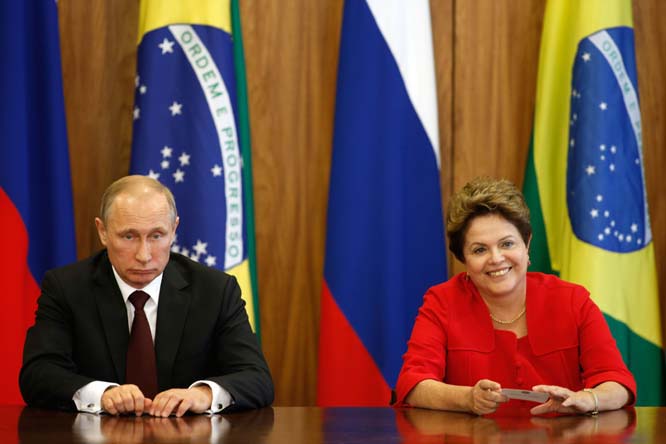Russia's President Vladimir Putin (left) sits with Brazil's President Dilma Rousseff during an agreement signing ceremony at Planalto Presidential Palace in Brasilia, Brazil on Monday. Putin is in Brazil to attend a presidential summit of the BRICS grou