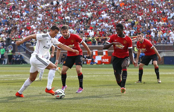 Real Madrid forward Cristiano Ronaldo (from left) tries to get past Manchester United defenders Alexander Buttner, Tyler Blackett, and Phil Jones during a Guinness International Champions Cup soccer match at Michigan Stadium in Ann Arbor, Mich. on Saturda