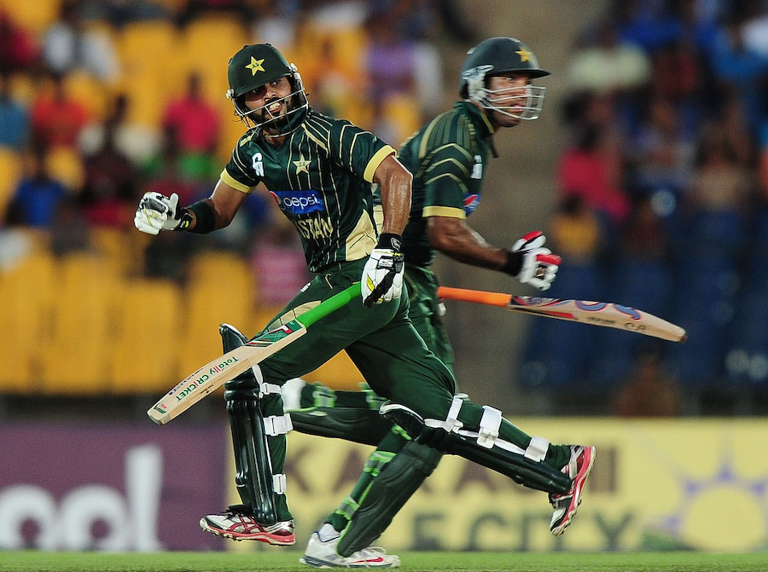 Pakistan batsman Fawad Alam (L) and Sohaib Maqsood (R) run between the wickets during the first One Day International (ODI) match between Sri Lanka and Pakistan at the Suriyawewa Mahinda Rajapakse International Cricket Stadium in the southern district of
