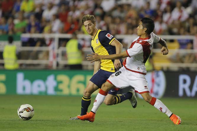 Rayo's Javier Aquino (right) vies for the ball with Atletico's Cristian Ansaldi (left) during a Spanish La Liga soccer match between Rayo Vallecano and Atletico Madrid at the Vallecas stadium in Madrid, Spain on Monday.