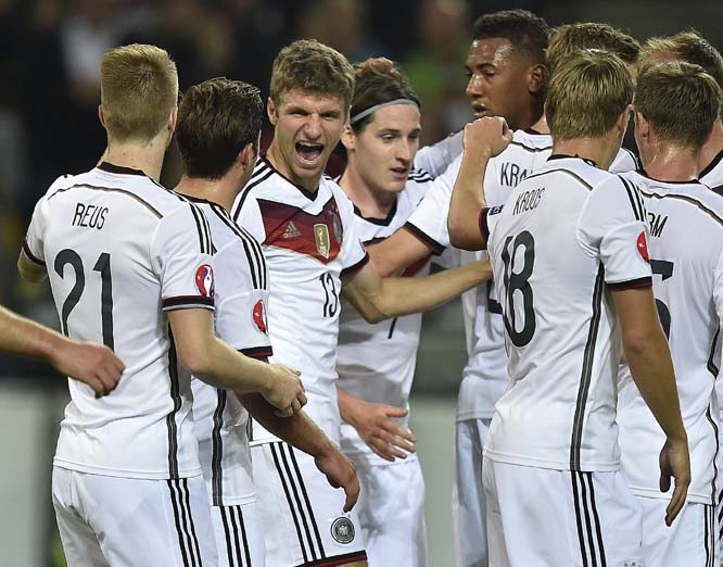 Germany's Thomas Mueller (center left) celebrates after scoring the opening goal with his head during the EURO 2016 soccer qualifying group D match between Germany and Scotland in Dortmund Germany on Sunday.