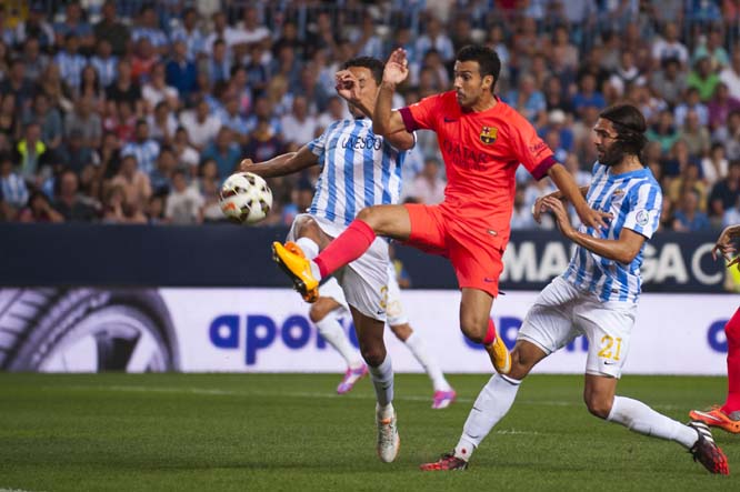 FC Barcelona's Pedro Rodriguez (center) in action with Malaga's Welligton Robson Pena de Oliveira from Brazil (left) and CF Malaga's Sergio Sanchez (right) during a Spanish La Liga soccer match between Malaga and Barcelona at La Rosaleda stadium in Ma