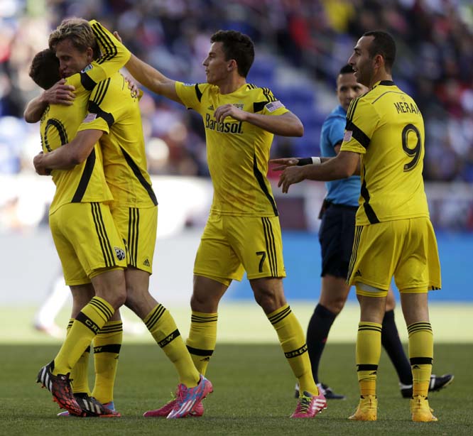 Columbus Crew's Aaron Schoenfeld (second from left) is hugged by Wil Trapp, left, as teammates Bernardo Anor (second from front right) and Justin Meram (right) celebrate a goal by Schoenfeld against the New York Red Bulls during the first half of an MLS